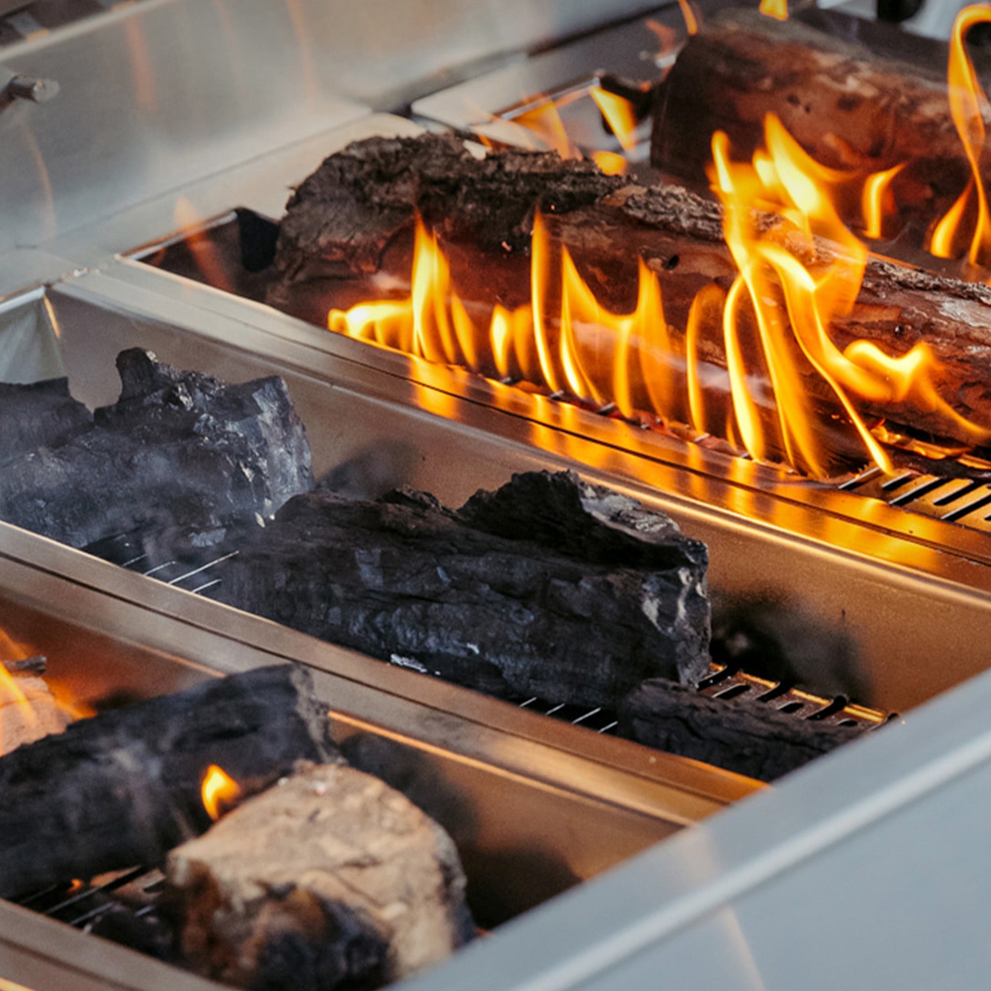 Muscle Hybrid Grill multi-fuel tray loaded with wood, detail view