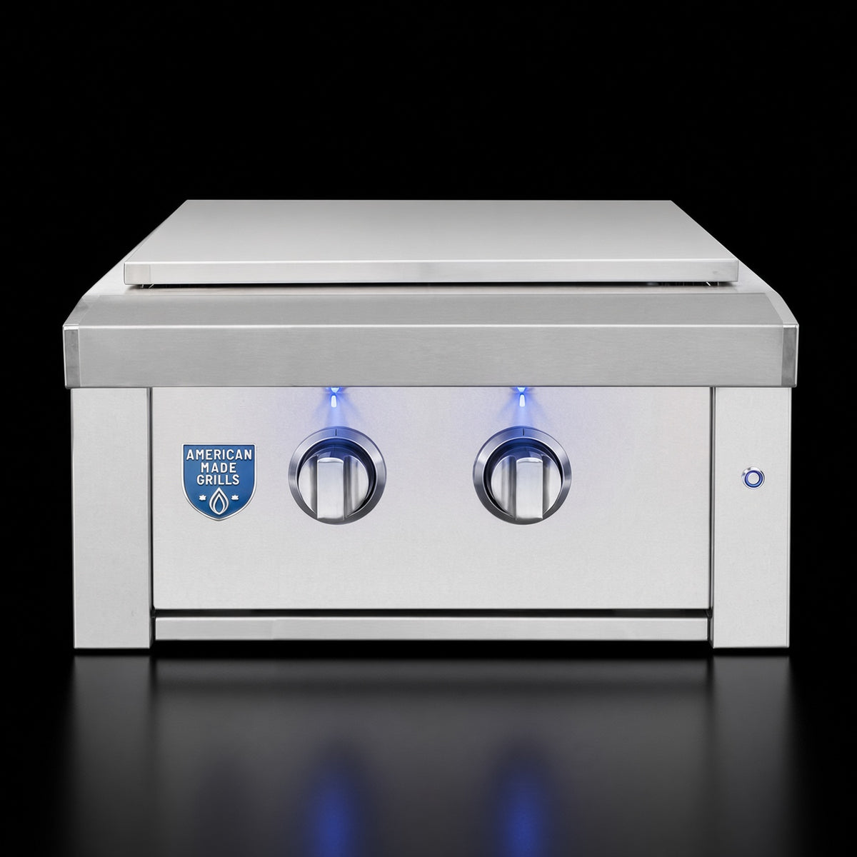 Estate Power Burner side burner, angled view with closed lid, illuminated knobs, and American Made Grills badge detail